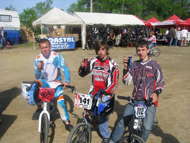 3 BMX riders in event in front of event tents